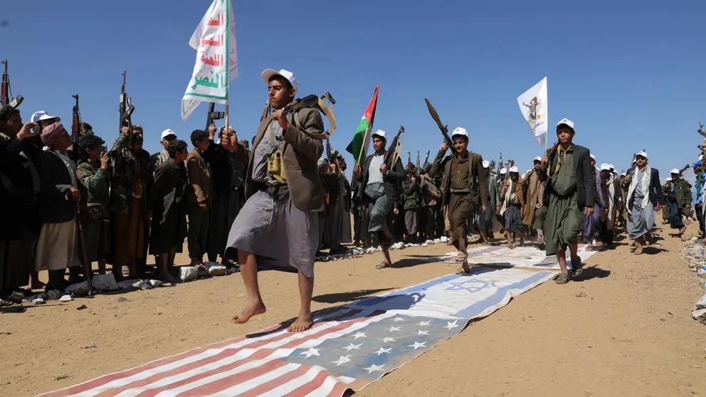 Tribesmen loyal to the Houthis march on U.S. and Israeli flags during a military parade for new tribal recruits amid escalating tensions in the Red Sea. Jan. 22,2024