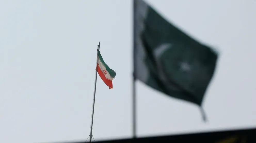 The flag of Iran is seen over its consulate building with Pakistan's flag in the foreground